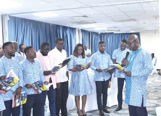 Dr Daniel Kasser Tee (right), National President of CIMG, swearing in new members of the organisation 
