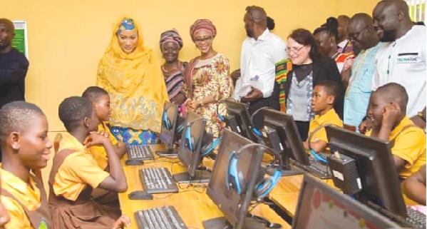 Hajia Samira Bawumia (left), wife of the Vice-President, joined by Mariam Iddrisu (3rd from left), MCE for Sagnarigu, and other guests to observe the school pupils demonstrate their computer skills at the launch of the ICT Lab In Tamale.