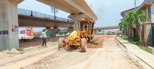 A grader levelling the road at the Nungua Interchange site