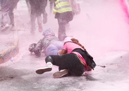 People fell as they run after police use water cannon to disperse protesters during a demonstration against Kenya's proposed finance bill 2024/2025