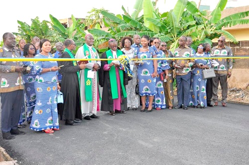  Rt Rev. Professor Joseph M.Y. Edusa-Eyison (4th from left), Methodist Bishop of the Northern Accra Diocese, cutting the tape to open the constructed asphalt road to traffic. Assisting him to do so is Rt Rev. Samuel Kofi Osabutey, Superintendent Minister of the Dzorwulu Circuit, while some church members look on