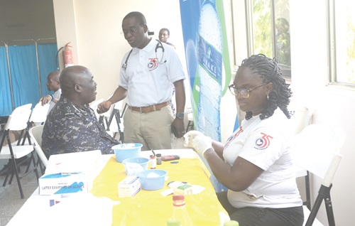  Dr Kow Entsua-Mensah, Director, National Cardiothoracic Centre, interacting with a police officer who was going through the health screening process.