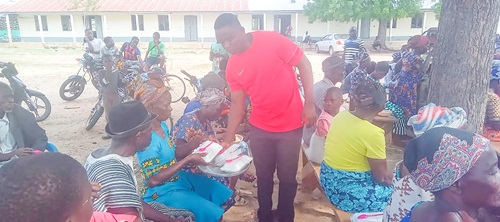 Amoah Norbert Achemwira, Vice-Chairman, Finance Committee, St Paul Miki Catholic Church, distributing packs of food to the aged during the event