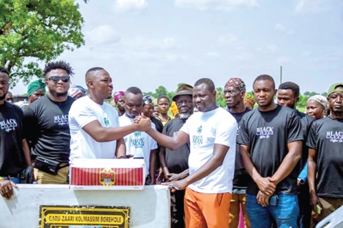 Edward Anafo Abambila (2nd from left), a representative of Charger Limited, handing over the borehole to Mahama Kassim (3rd from right), the Assembly member for the area. INSET: The new borehole