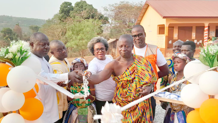 Nana Appiah Antwi (2nd from right), Odikro of Abuorso, being assisted by Charles Oware Tweneboah (left), DCE for Fanteakwa North, to cut the tape to inaugurate the facility. Looking on are officials from World Vision