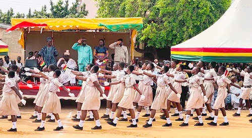 Kofi Ofori (arrowed), MCE for Ablekuma North Assembly, taking the salute while pupils of Odorkor Maclean Basic School march past