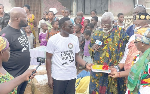 Dr Kobby Boateng (2nd from left), President of the Ghana Association of Sports Betting Operators, presenting learning materials to leaders of Anyako