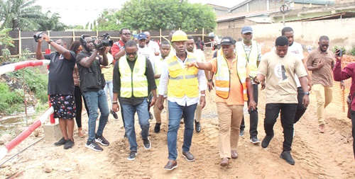 Dr Ohene Sarfo (2nd from right), Project Coordinator, GARID, conducting Kojo Oppong Nkrumah (middle), Minister of Works and Housing, round the drainage construction site at Alogboshie. With them are some journalists and other engineers. Picture: ERNEST KODZI