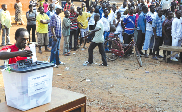  A voter exercising his franchise in a presidential election with others in a queue waiting to cast their ballot