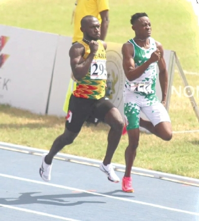 Ghana's Benjamin Azamati (left) in action in the men's 100m heats yesterday