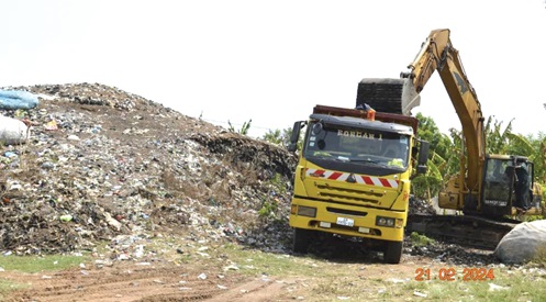 A pay loader clearing refuse into a tipper truck at the Okonya community to be carted away