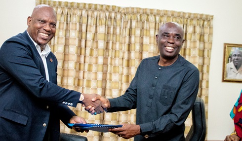 Ato Afful (left),  Managing Director, GCGL, and  Prof. Abednego F. Okoe Amartey, Vice Chancellor, UPSA,  exchanging documents after signing the MOU in Accra