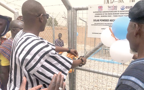 Daniel Anania Atampoba, DCE for Bawku West, cutting the tape to inaugurate one of the boreholes. Inset: One of the solar-powered mechanised boreholes