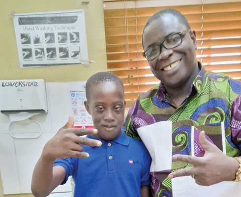 Dr Frank Owusu-Sekyere (right), the writer, and Joseph Tetteh with Down Syndrome making a sign for “Ending the Stereotype"