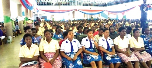 Some of the students of Krobo Girls SHS listening attentively to the speakers. INSET:  Evelyn Oye Lamptey, Guest speaker, delivering her speech 