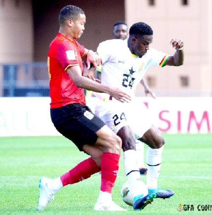 Ernest Nuamah (right) and his Ugandan marker in a tussle for the ball