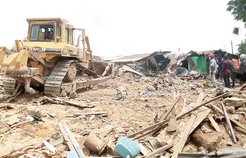 An excavator pulling down the structures