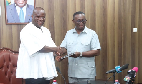  Andy Appiah Kubi (right), Chairman of the Devesting Committee and Member of Parliament for Asante-Akim North Constituency, presenting the report to Samuel Abu Jinapor (left), Minister of Lands and Natural Resources, after the meeting with the committee. Picture: ELVS NII NOI DOWUONA