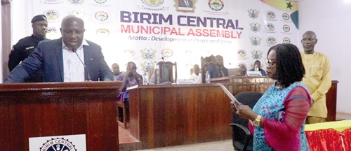 Joyce Adjoa Agyeiwaa (standing right) swearing the oath of office being administered by Seth Kwame Acheampong, the Eastern Regional Minister (left)