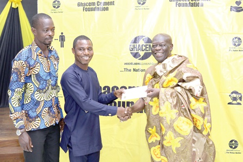 Ehunabobrim Prah Agyensaim VI (right), handing over cement allocation chit to representatives of a beneficiary institution 