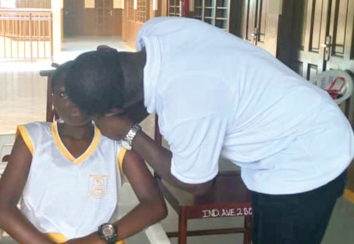 Dr Samuel Asiedu, Director, Iris Optometric Practice, checking the eye of the beneficiary students 
