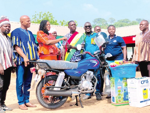  Mavis Akonnor, the DCE for Asuogyaman, handing over the  keys to the motorbike to Stephen Kwame, the best farmer