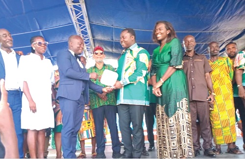Paul Afoakwah Okyere (3rd from left), the district's best teacher, receiving a shield from Rev. John Ntim Fordjour (3rd from right), the Deputy Minister of Education