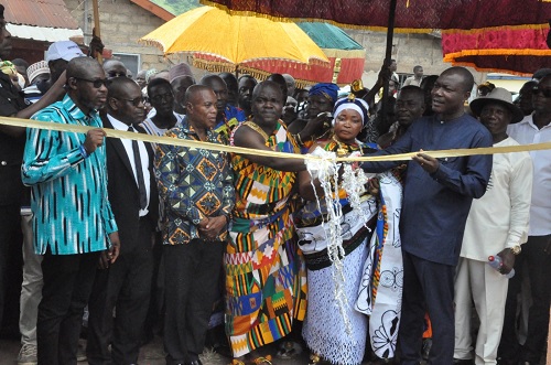 Togbe Abutia Kodzo Gidi V (middle, in kente), Paramount Chief of Abutia, Mama Afibaa Agbovi V, Queen of Amanflu and a member of the Dorfor Traditional Council, and Baafi Nsiah, Chief Registrar at the Ministry of Chieftaincy and Religious Affairs, jointly performing the tape-cutting while other dignitaries look 