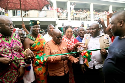 President Akufo-Addo (3rd from left) being assisted by Oseadieyo Dr Frimpong Manso iv (2nd from left), Seth Kwame Acheampong (right), Eastern Regional Minister, and other dignitaries to cut the tape to inaugurate the new market