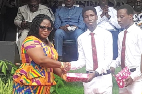 An invited guest presenting an award to one of the students
