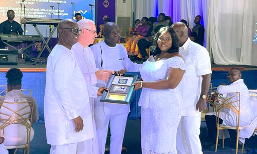 Rev. Father Andrew Campbell (second from left) presenting the longest service award to Portia Obeng Ayeh