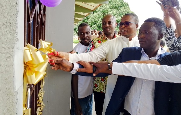 Rev. Fr Gordon Tawiah (2nd from right), Acting Rector of the school, being assisted by Williams Mensah (right), President of the 2000-year group and other group members to cut the tape to inaugurate the facility.