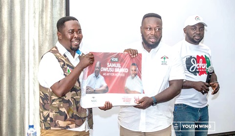 George Opare Addo (middle), the National Youth Organiser of the NDC, handing over a bundle of posters to Mark Oliver Kevor (left), the Eastern Regional Chairman of the NDC