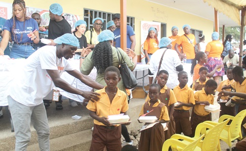 Joseph Konlan (left), Accounts Officer, Food For All Africa, distributing food to some schoolchildren to commemorate World Food Day, held at Street Academy, Arts Centre in Accra.  Picture: ESTHER ADJORKOR ADJEI 