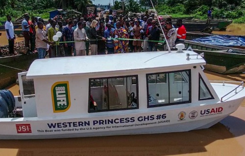 USAID/Ghana Mission Director, Kimberly Rosen, Ghana Health Service representatives, and traditional leaders cut the ribbon to officially hand over boats to the community.