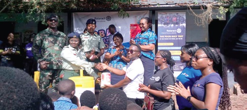 Giovanni Nautical Obuobi (4th from right), President of the Rotaract Club Accra-Labone, handing over the materials to officials of the school