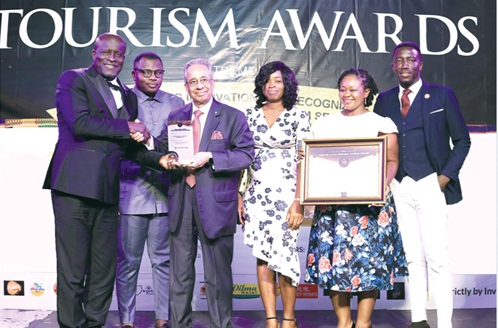 Sajid Khan (3rd from left), General Manager, Tang Palace Hotel, receiving the award from Titus Glover (left), Greater Accra Regional Minister, at the event with some staff looking on