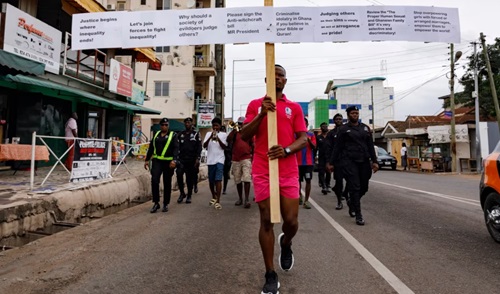 Texas Kadri Moro, the executive director of Arise for Justice International, protests with placards nailed on a cross on the street of Accra, Ghana, Sept. 12, 2024.