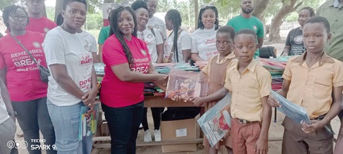 Jennifer Puplampu (first left), the deputy director of Human Resource in charge of administration together with Beatrice Baiden(second left) presenting some of the items to some pupils  at the event