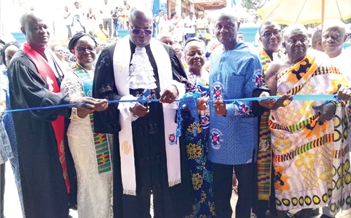 Rt Rev. Dr Abraham Nana Opare Kwakye (3rd from left), Moderator of the General Assembly of the Presbyterian Church of Ghana, being assisted by Daniel Kwaku Botwe (2nd from right), Member of Parliament (MP) for Okere, Rev. Benjamin Appiah (left), Chairperson of Brong Ahafo Presbytery, and some chiefs to cut the tape to inaugurate the newly constructed manse