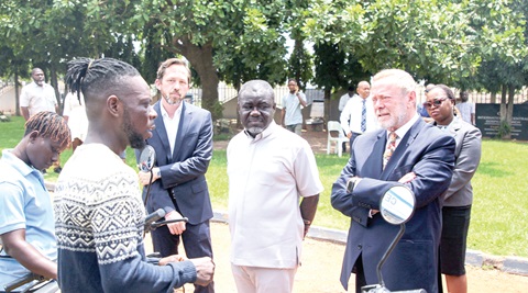 Lord Collins (right), UK Minister for Africa, and Kwaku Ofori- Asiamah (2nd from right), Minister of Transport, being briefed by a staff of Kofa, an e-bike and battery company in Accra