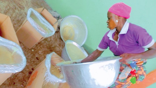 Bamunu Mohammed packing shea butter to weigh for her payment