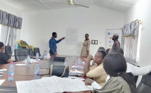 Aaron Essuman (standing left), a participant from the Cape Coast Metropolis implementing area, making a presentation