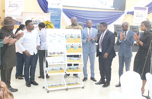 Prof. Peter Quartey (3rd from right), Director, ISSER, launching the report. Applauding are Kwame A. Oppong (4th from right), Head of Fintech, BoG; Prof. Ernest Aryeetey (5th from right), former Vice-Chancellor, UG; Dr Kenneth Ashigbey (left), CEO, Ghana Chamber of Telecommunications; Prof. Francis Annan (2nd from left), Economist, UC Berkeley, and other dignitaries. Picture: ERNEST KODZI