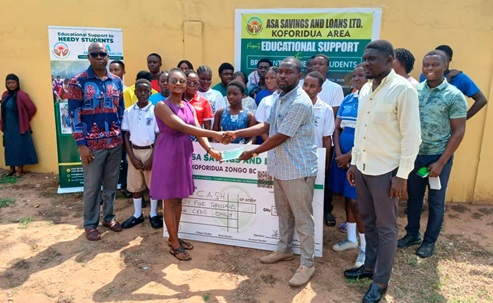 Godson Adzafi (2nd from right), Koforidua Area Manager of ASA Savings and Loans Limited, presenting a cheque to Rhoda Osabutey (left), student from SDA College of Education