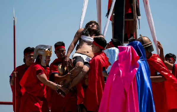 Ruben Enaje is carried after being nailed to the cross during his reenactment of the crucifixion of Jesus Christ on Friday