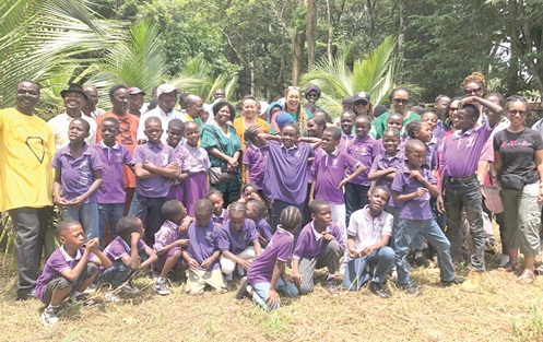 Pupils from Anane Memorial International School with members from the three organisations after the coconut planting exercise