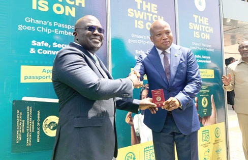 Julius Debrah (left), Chief of Staff, receiving a copy of the passport from Samuel Okudzeto Ablakwa, the Minister of Foreign Affairs