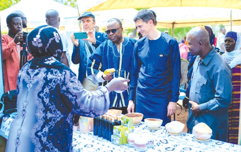 Jules-Armand Aniambossou (middle in smock), French Ambassador to Ghana, inspecting some products exhibited by the women cooperatives