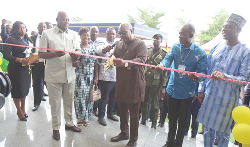 President John Dramani Mahama (middle) being assisted by Joseph Bukari Nikpe (left), Minister of Transport; Rev. Stephen Wilfred Arthur (2nd from right), acting Director-General, Ghana Civil Aviation Authority, and Muntaka Mohammed-Mubarak (right), Interior Minister, to commission the new ANS facility